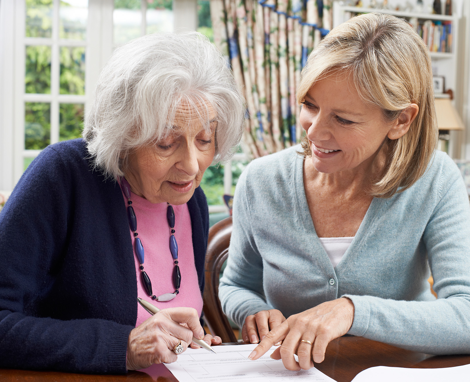 Woman Helping Senior Woman To Complete Form