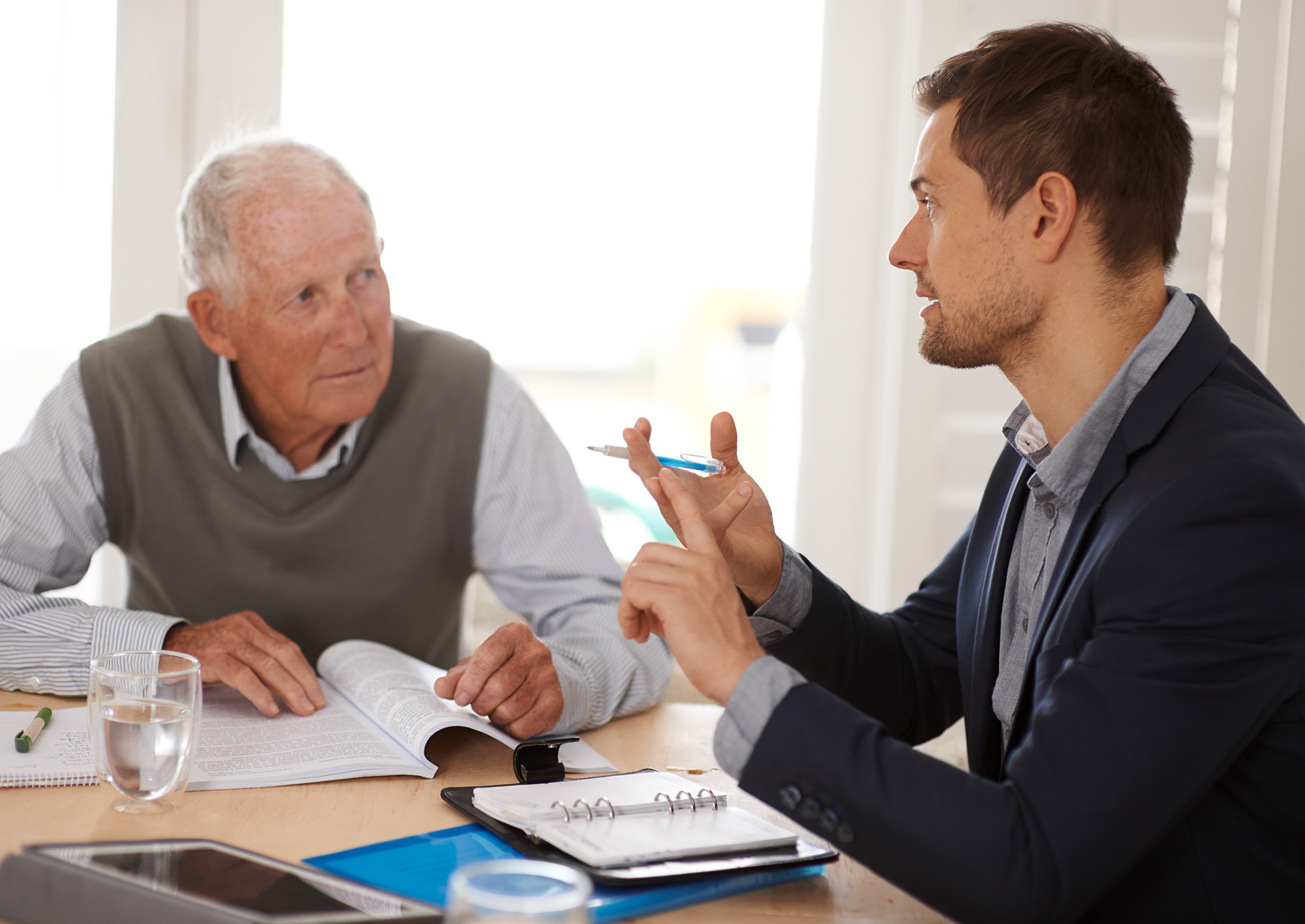 Financial advisor talking to a senior man with an investment, savings or retirement planning. Discussion, documents and professional accountant helping an elderly male person with finance paperwork